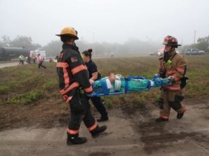 Two firefighters carrying a person on a stretcher